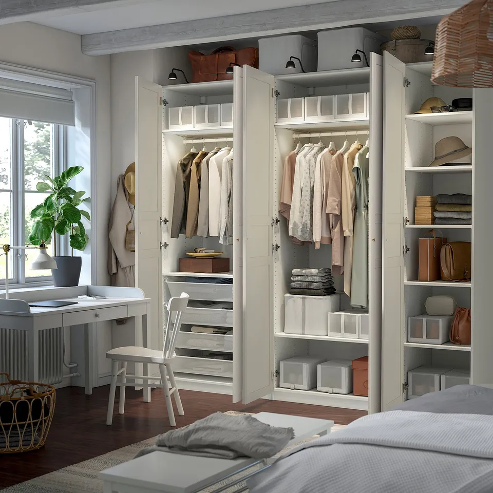 Open wardrobe with clothes, shelves, and drawers. Clothes hang neatly inside with additional storage solutions.