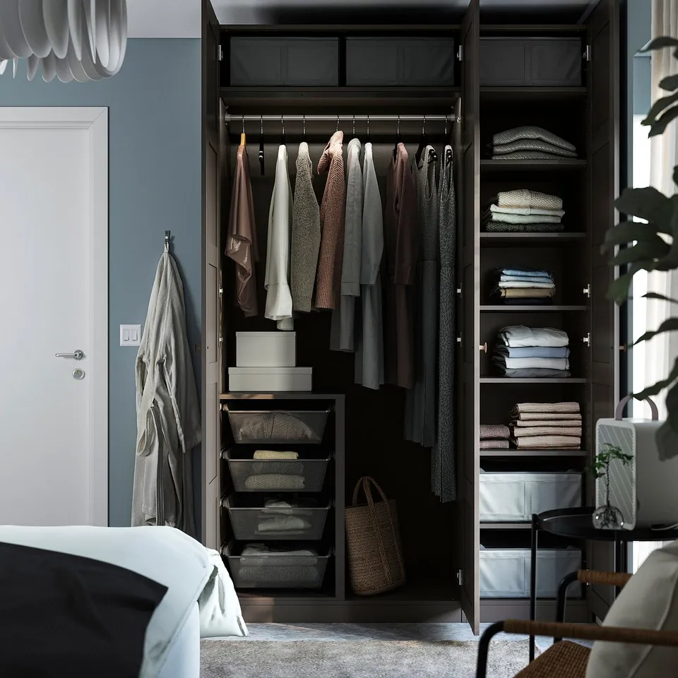 Open wardrobe displaying organised clothes, shelves, and storage bins in a bedroom setting.