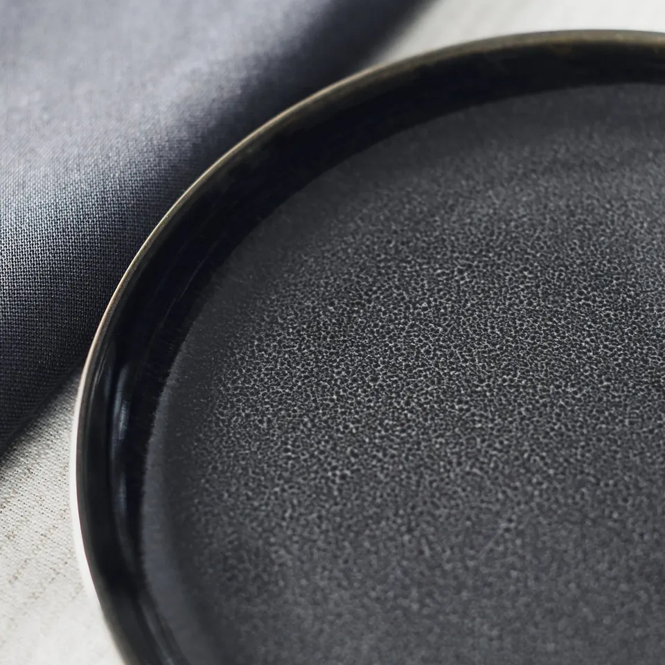Black plate on dark cloth.