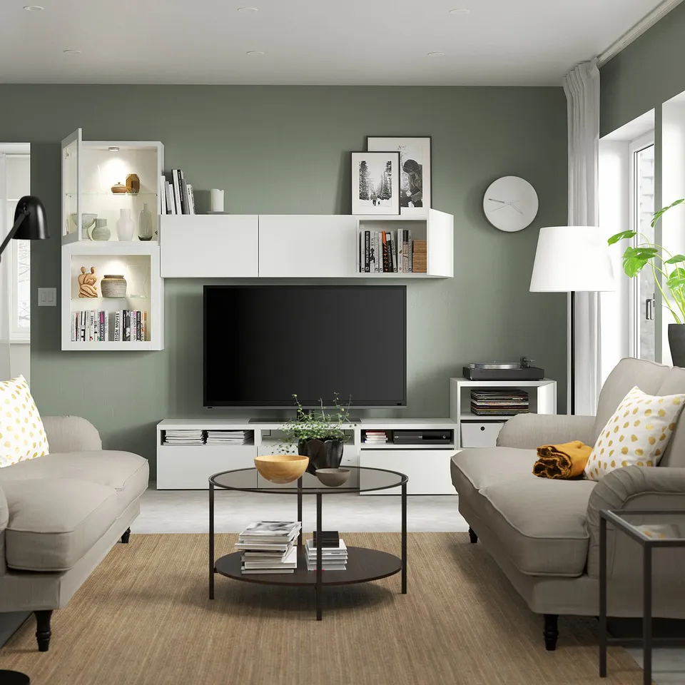 Modern living room with BESTÅ tv storage, shelves, cable outlet, grey sofas, coffee table, and flat-screen tv.