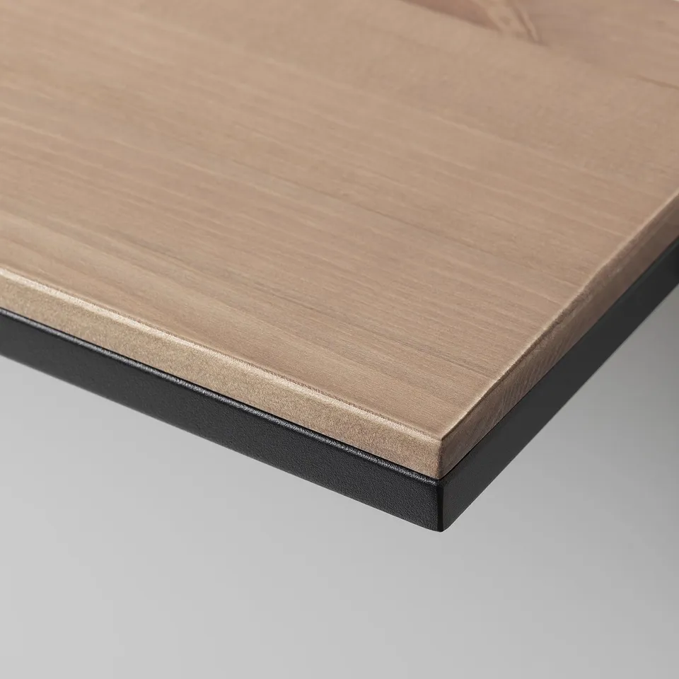 Close-up of rustic shelf edge, showing fine wood grain texture and smooth black metal frame.
