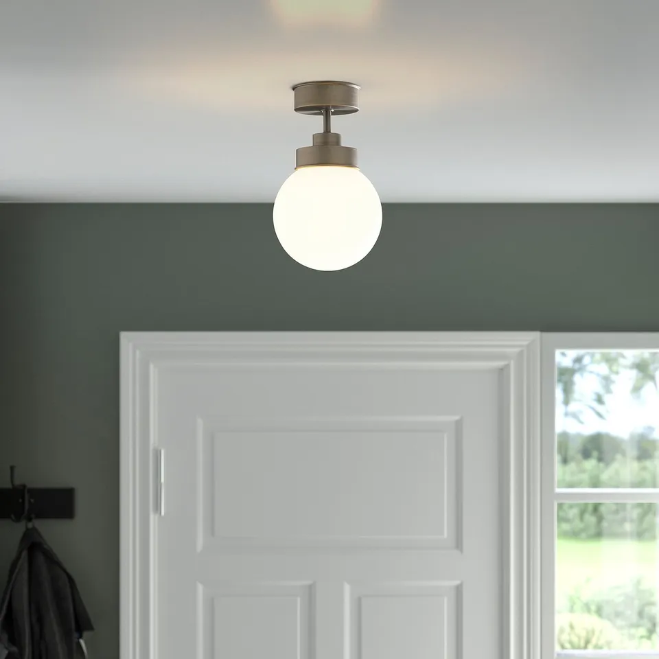 A hanging light fixture with a glass globe shade illuminates a white door, providing balanced lighting.