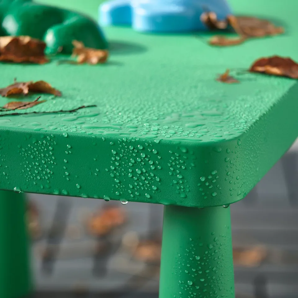 Close-up of green childrens table with water droplets, perfect for outdoor play.