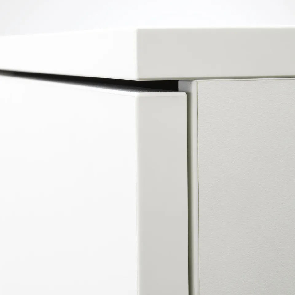 Close-up of white cabinet corner, showing clean, modern design with sleek edges and neat finish.