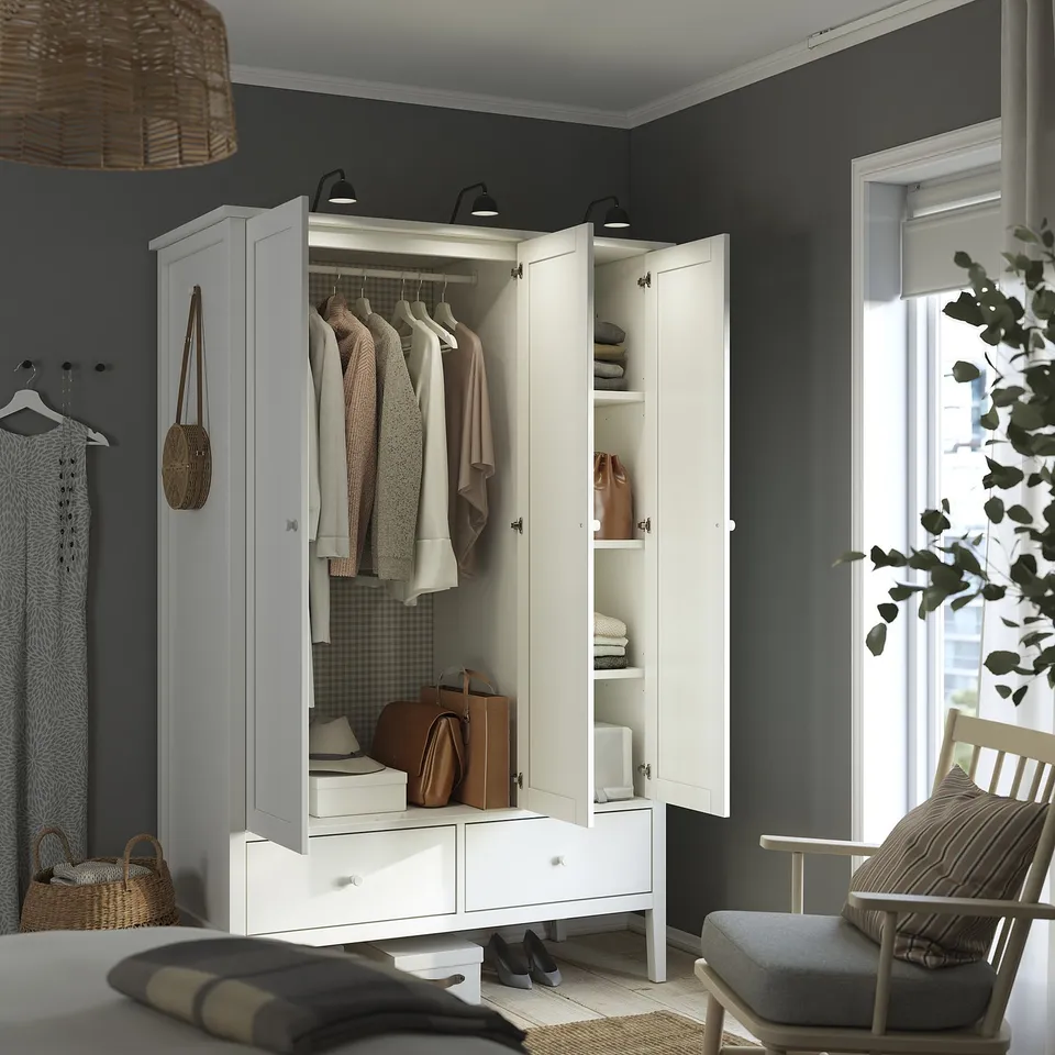 Modern bedroom with GULLABERG wardrobe, dark walls, wood chair, and plant.