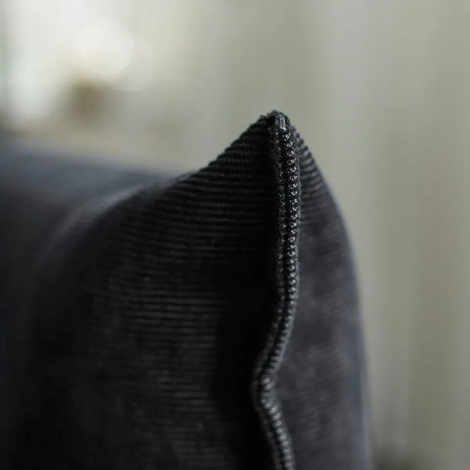 Close-up of high-quality, dark fabric with neat stitching; durable, elegant texture.