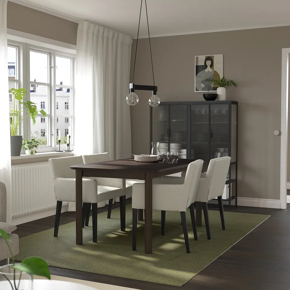 Modern dining area with STRANDTORP table and chairs, pendant lights, cabinet, rug, and window.