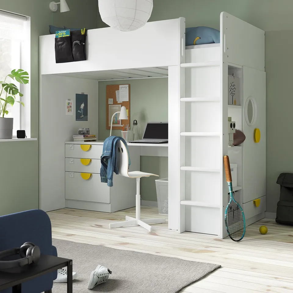 Kids room with SMÅSTAD loft bed, desk, and storage. Green walls, blue accents, wooden floors, chair, rug, sports gear.