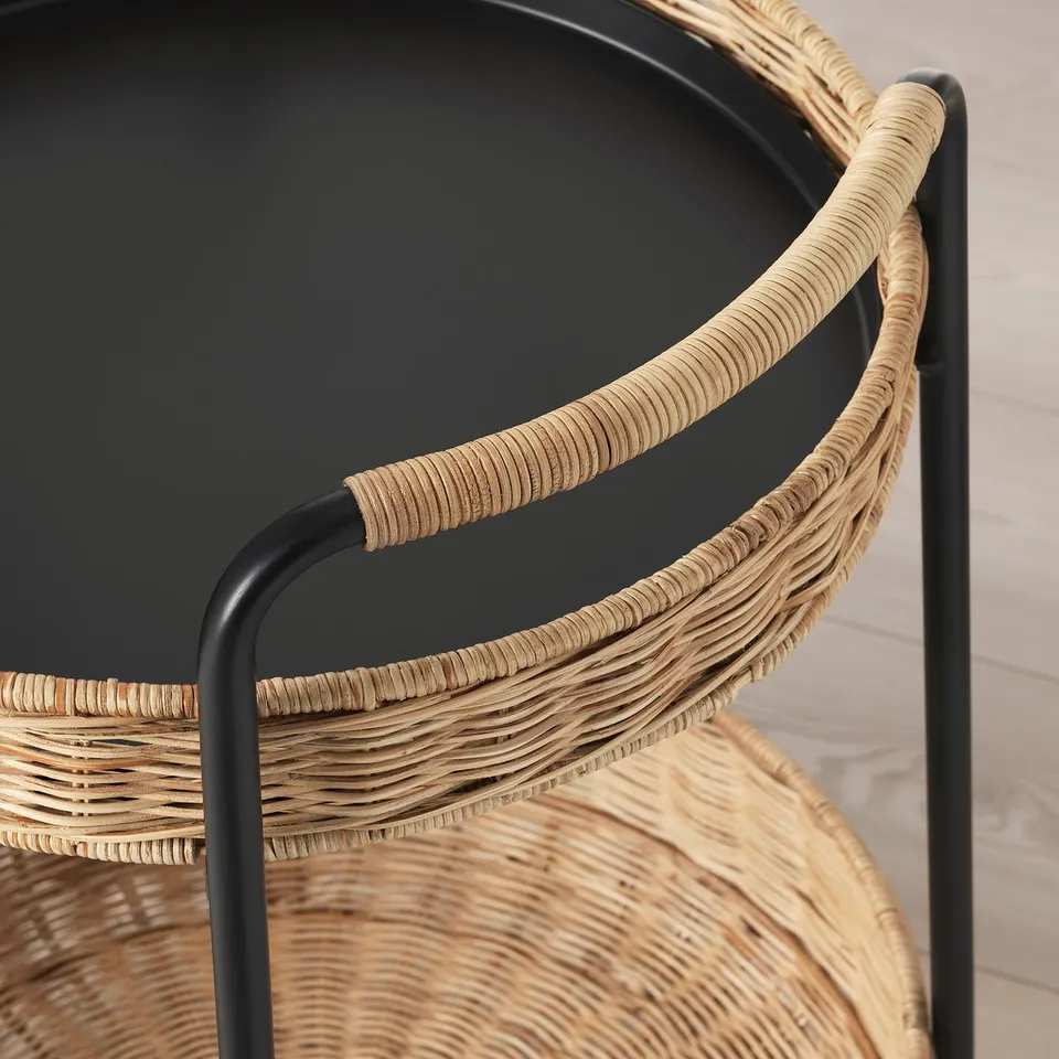 Modern rattan chair with sleek black metal frame, woven seat, and armrests.