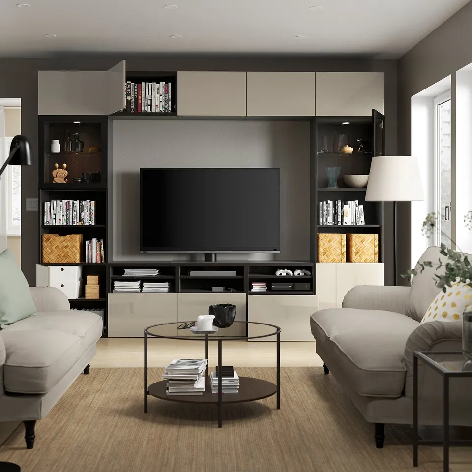 Modern living room with a BESTÅ tv storage combination featuring a flat-screen tv, adjustable shelves, wall cabinets, and soft-closing drawers.