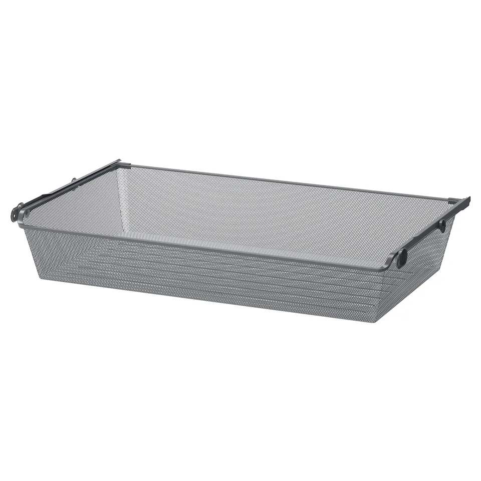 A grey KOMPLEMENT mesh storage basket with metal handles and edges, ideal for storing clothes and textiles.
