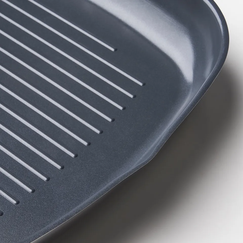 Close-up of high-quality, ribbed IKEA 365+ grill pan. Smooth, non-stick surface for easy cooking.