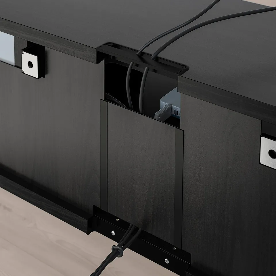 Black tv stand with adjustable shelves and cable management system, showing cables routed through back outlet.