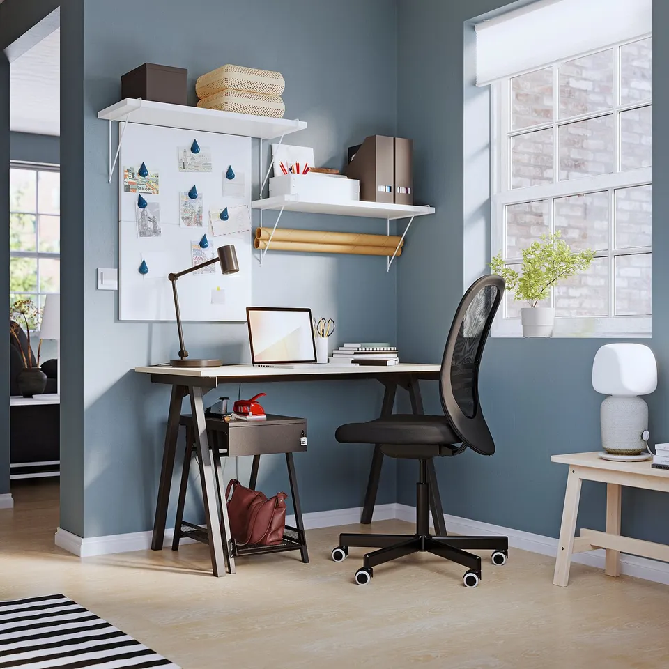 Modern blue home office with TROTTEN black desk, mesh chair, and shelves.