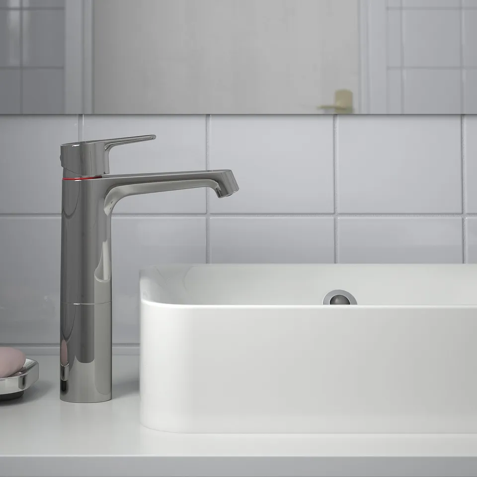 Modern chrome bathroom tap with lever handle, cold-start feature.