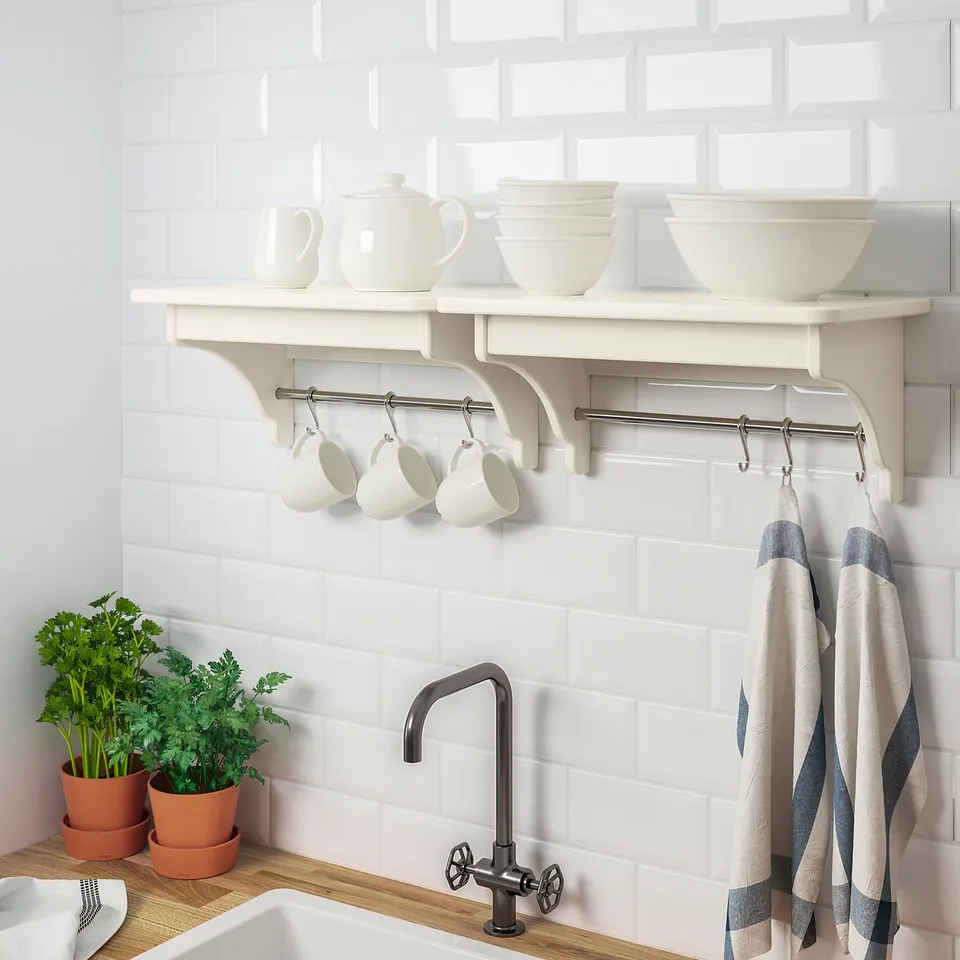 Kitchen shelf with hooks holding mugs and towels, displaying storage and organisation.