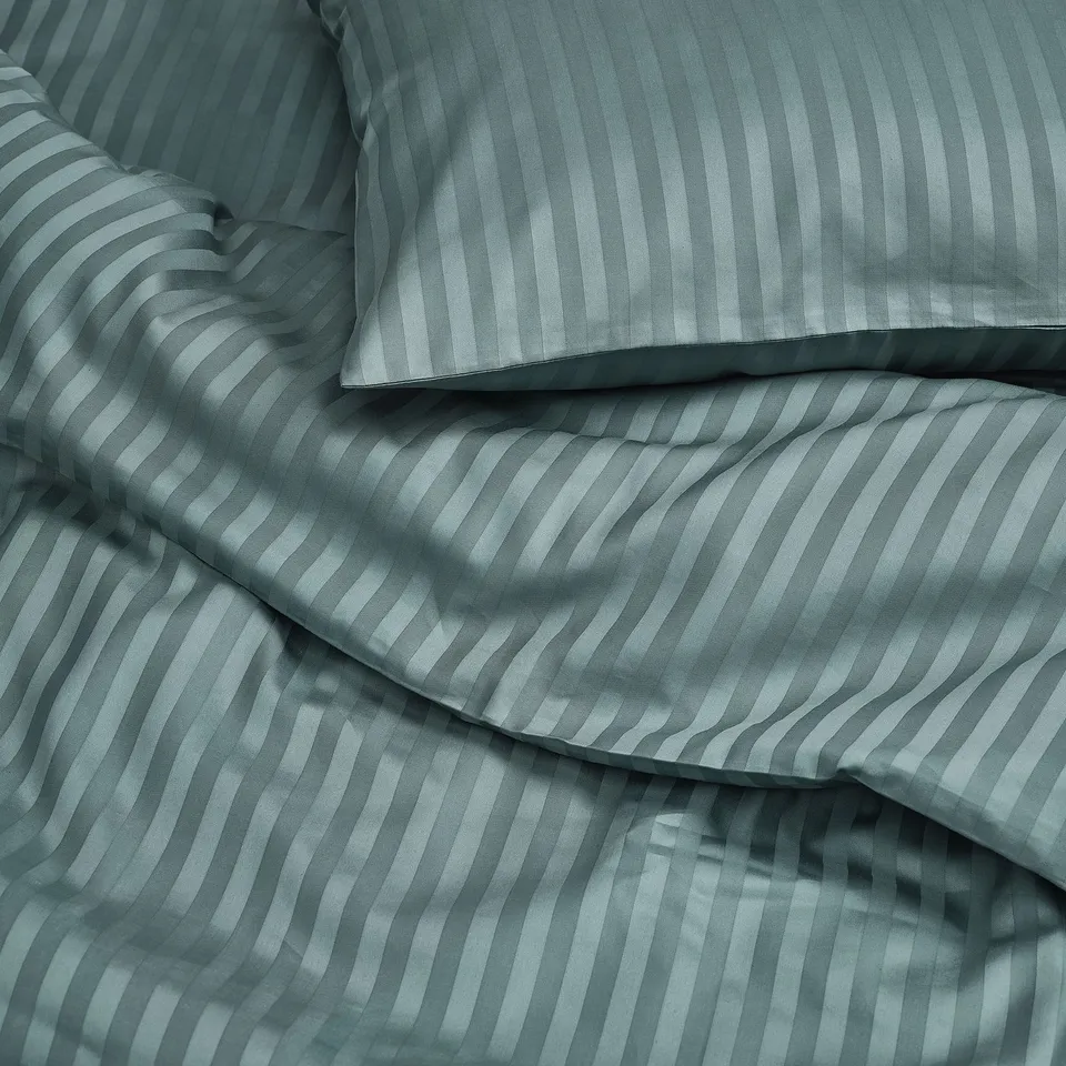 Steep blue sateen bedding with fine stripes, smooth and lustrous texture.