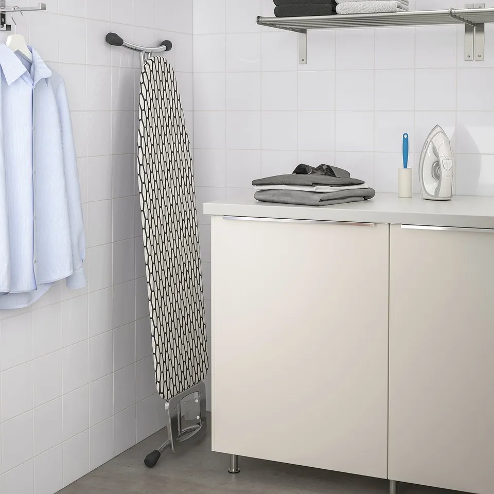 Ironing board with iron and folded clothes.