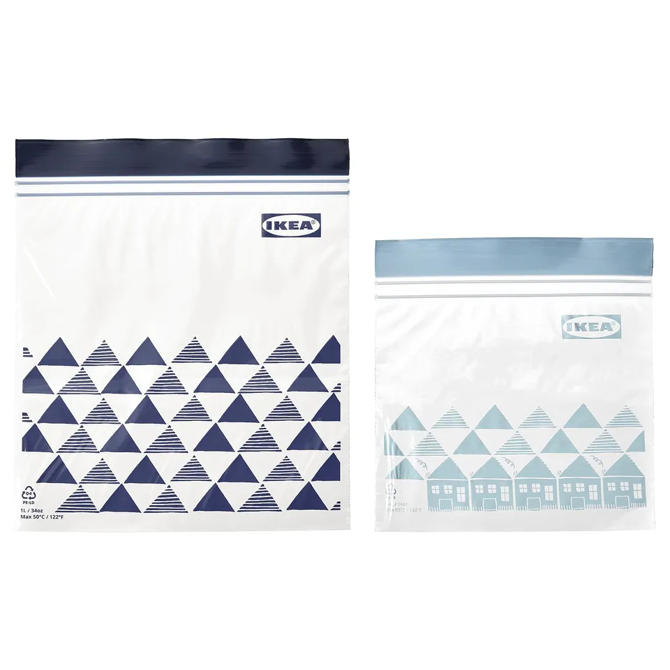 Two ikea sealed storage bags, one dark blue with triangle pattern, one light blue with house design.