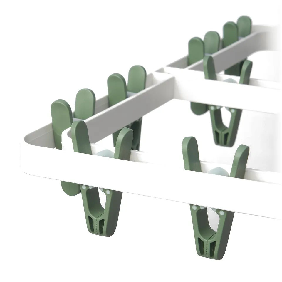 Image shows a white foldable hanging dryer with green clips. Quality design for drying small items.