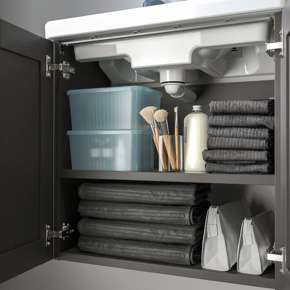 Cabinet with stacked boxes for organising bathroom items; boxes partly transparent with lid.