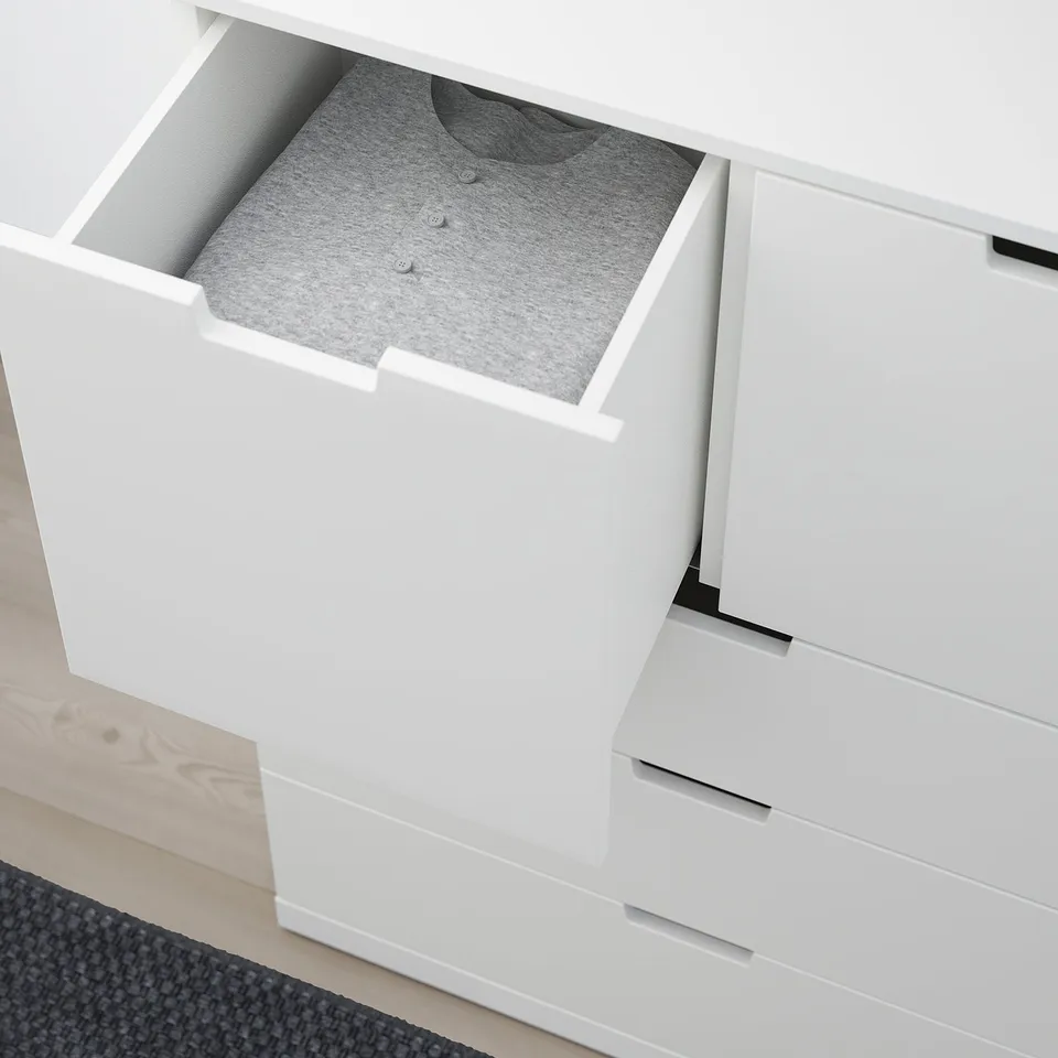 White chest drawer open, revealing grey shirt and soft-close feature.