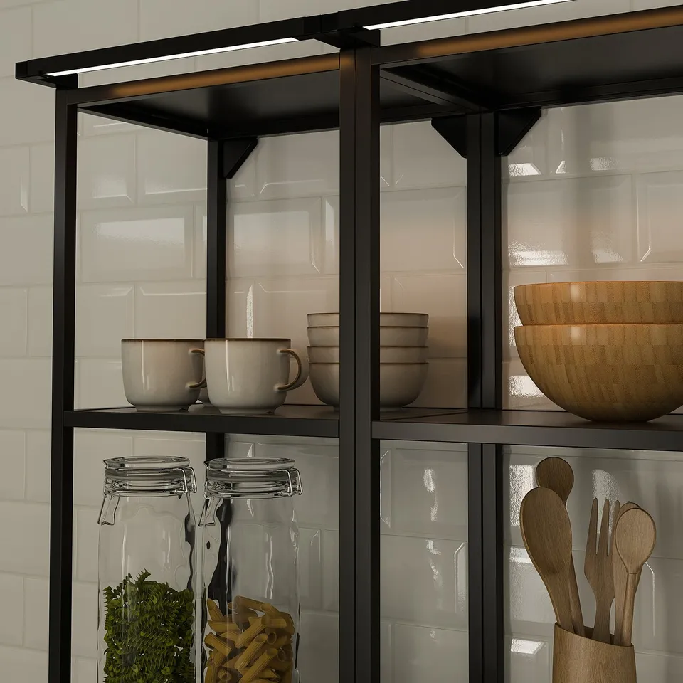 Shelving unit with interior lighting showcasing mugs, jars, and wooden utensils.