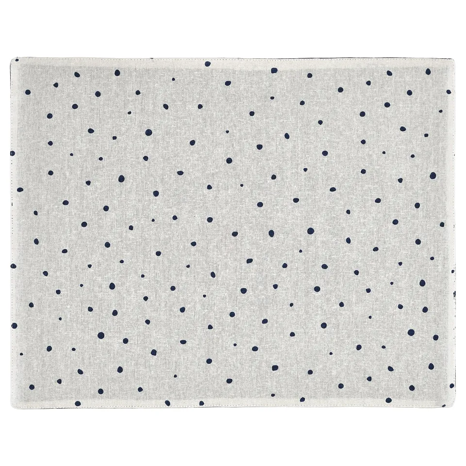 A beige and black polka dot reversible cotton place mat by ikea named NISSÖGA.