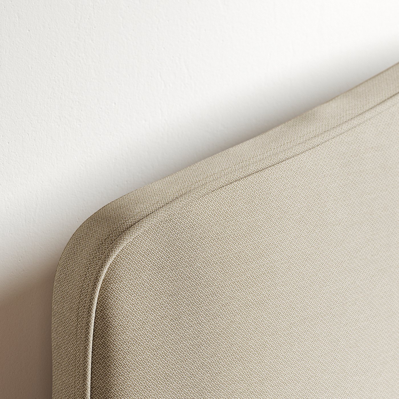 Close-up of a tailored edge of a padded headboard.