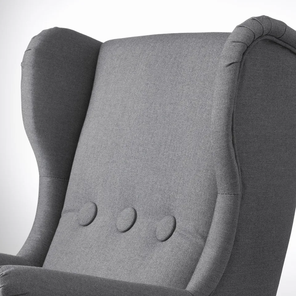 A high-quality grey STRANDMON kids armchair. Soft fabric and sturdy design ensure comfort and durability.