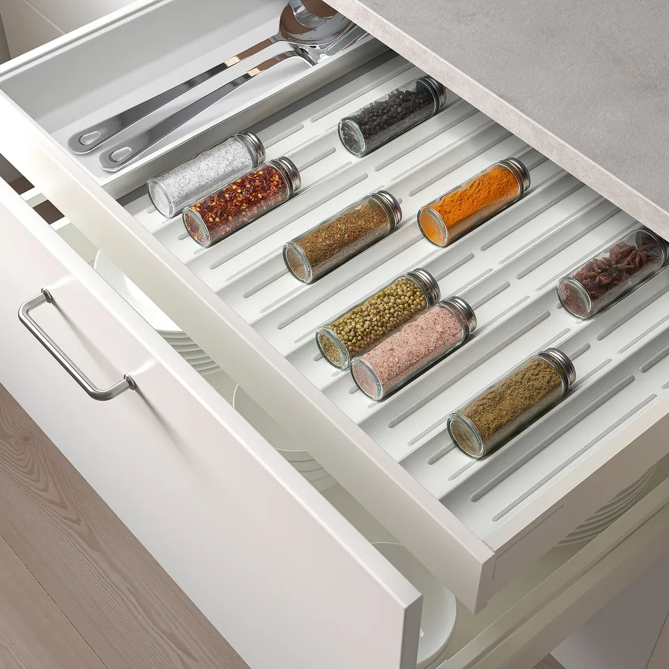 Spice drawer organiser keeps containers upright and visible, preventing spills, saving space, and aiding kitchen workflow.
