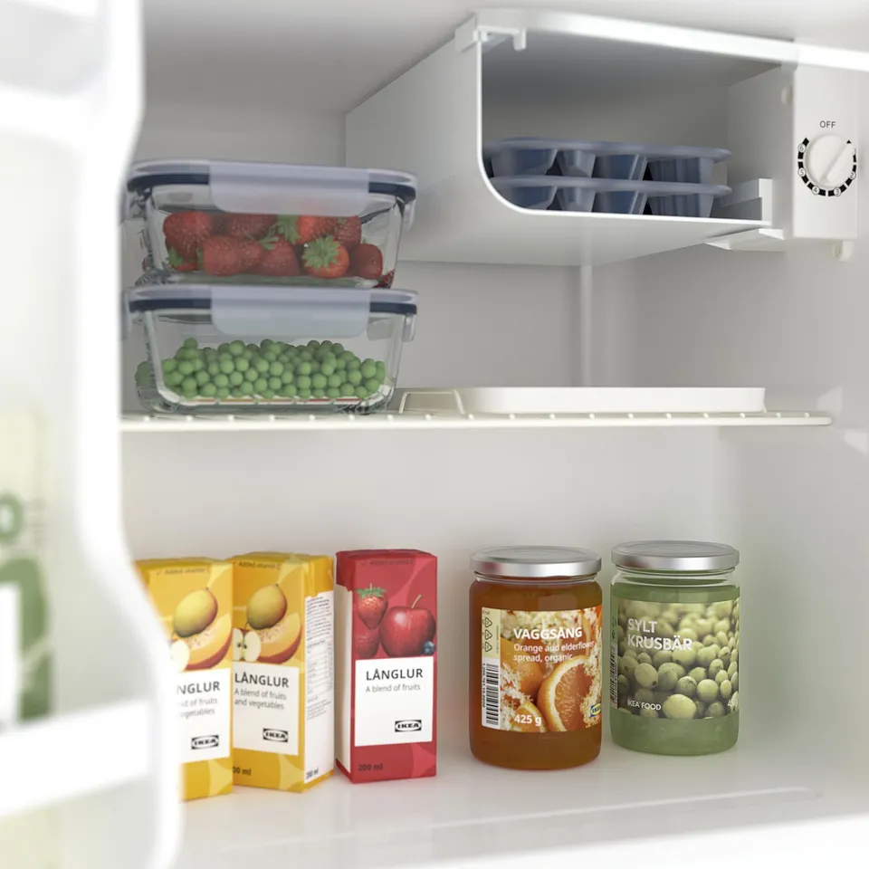A small fridge with fruit juices, jams, and fresh produce. It includes a chill compartment for cooling drinks and snacks.