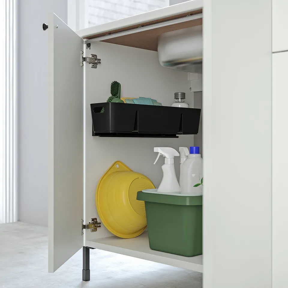 White cabinet shows black storage with green brushes, cloths, yellow container, and cleaning supplies. Pull-out for easy access.