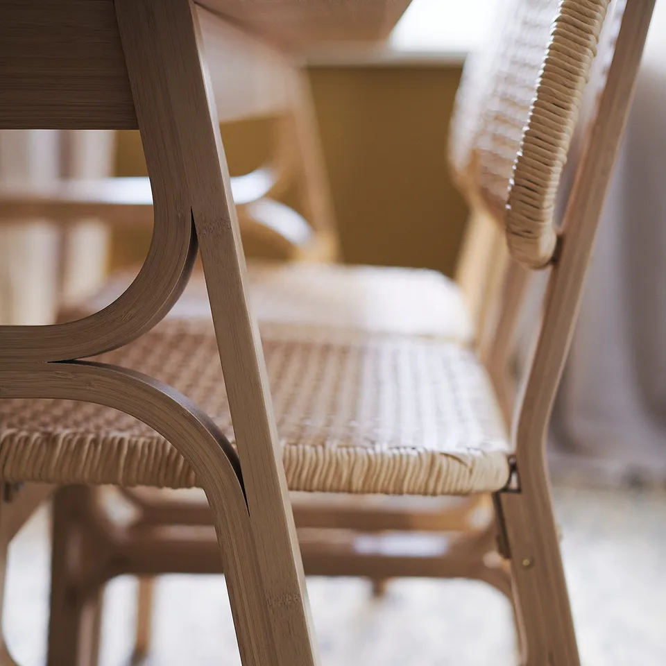 Two stacked VOXLÖV chairs, light brown bamboo frames, woven paper seats, on patterned rug.