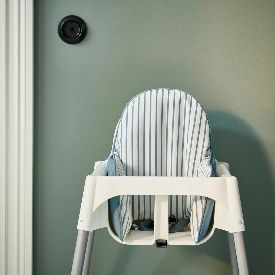 White high chair, blue cushion, green wall