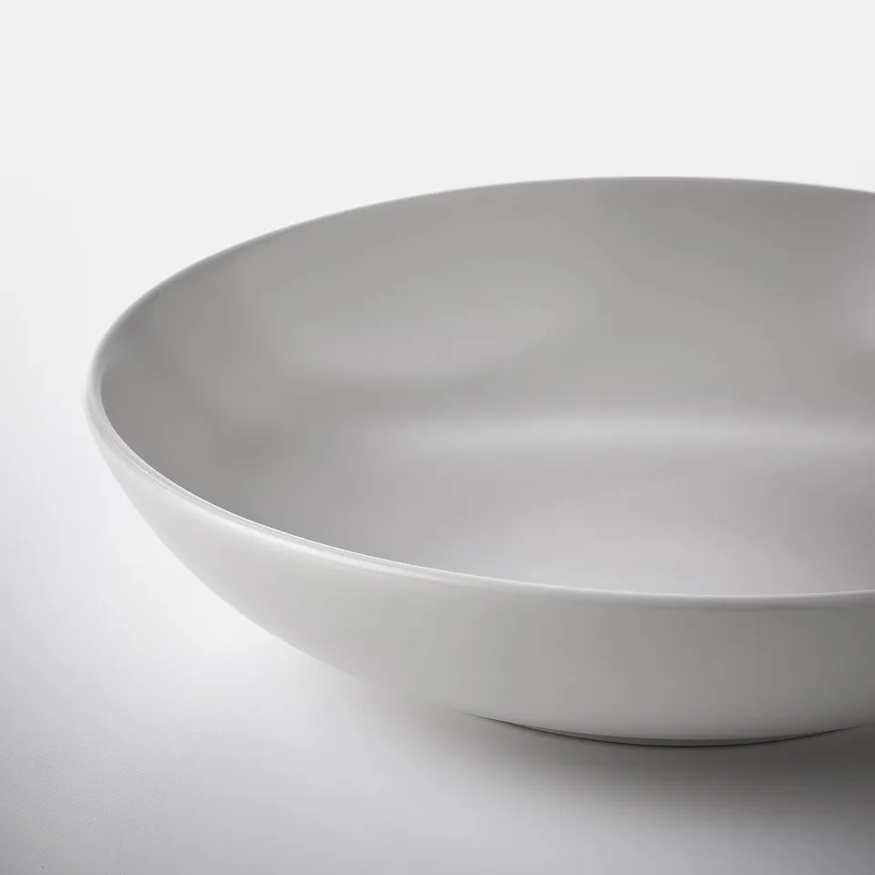 Smooth, matte white bowl with rounded edges on a white surface.