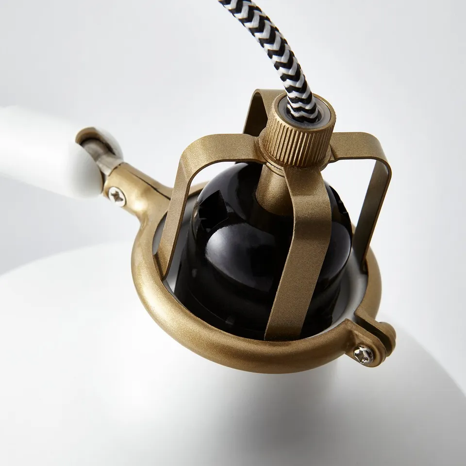 Gold adjustable lamp with black shade, sleek design, sturdy build.