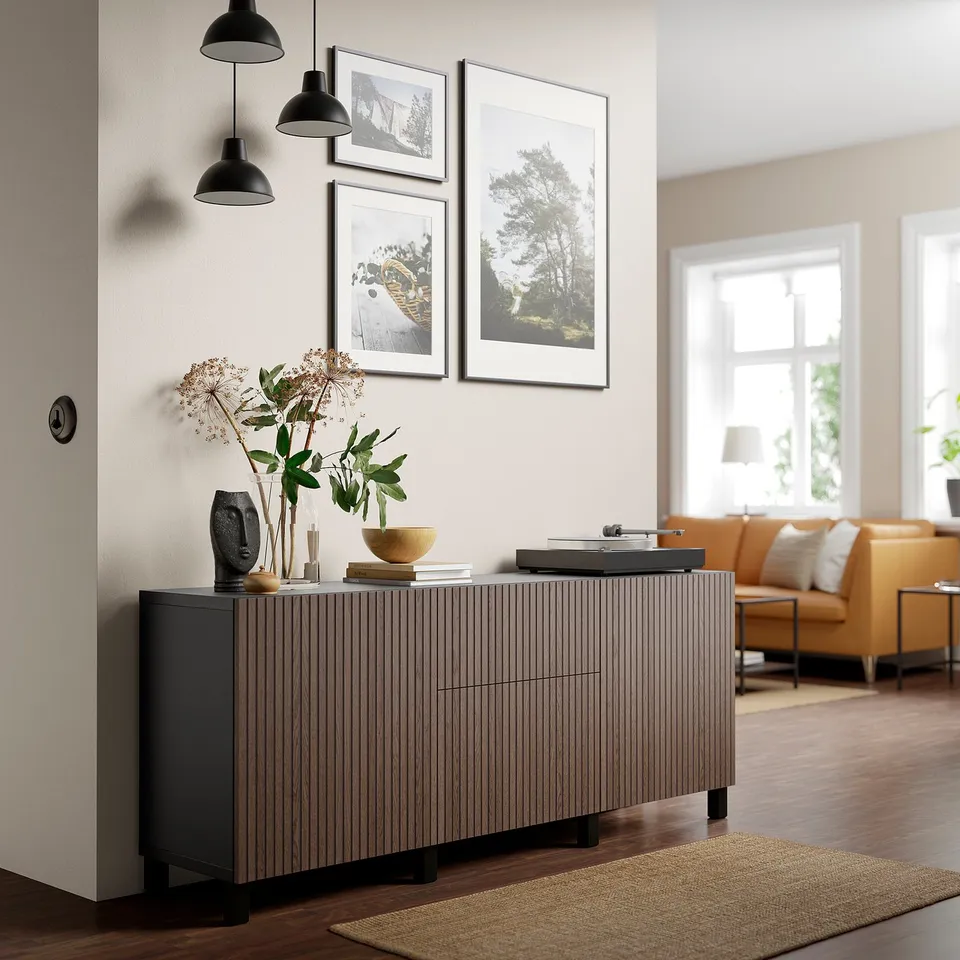 Modern living room with BJÖRKÖVIKEN cabinet, dark oak, orange couch, pendant lights, wood floors, and plants.