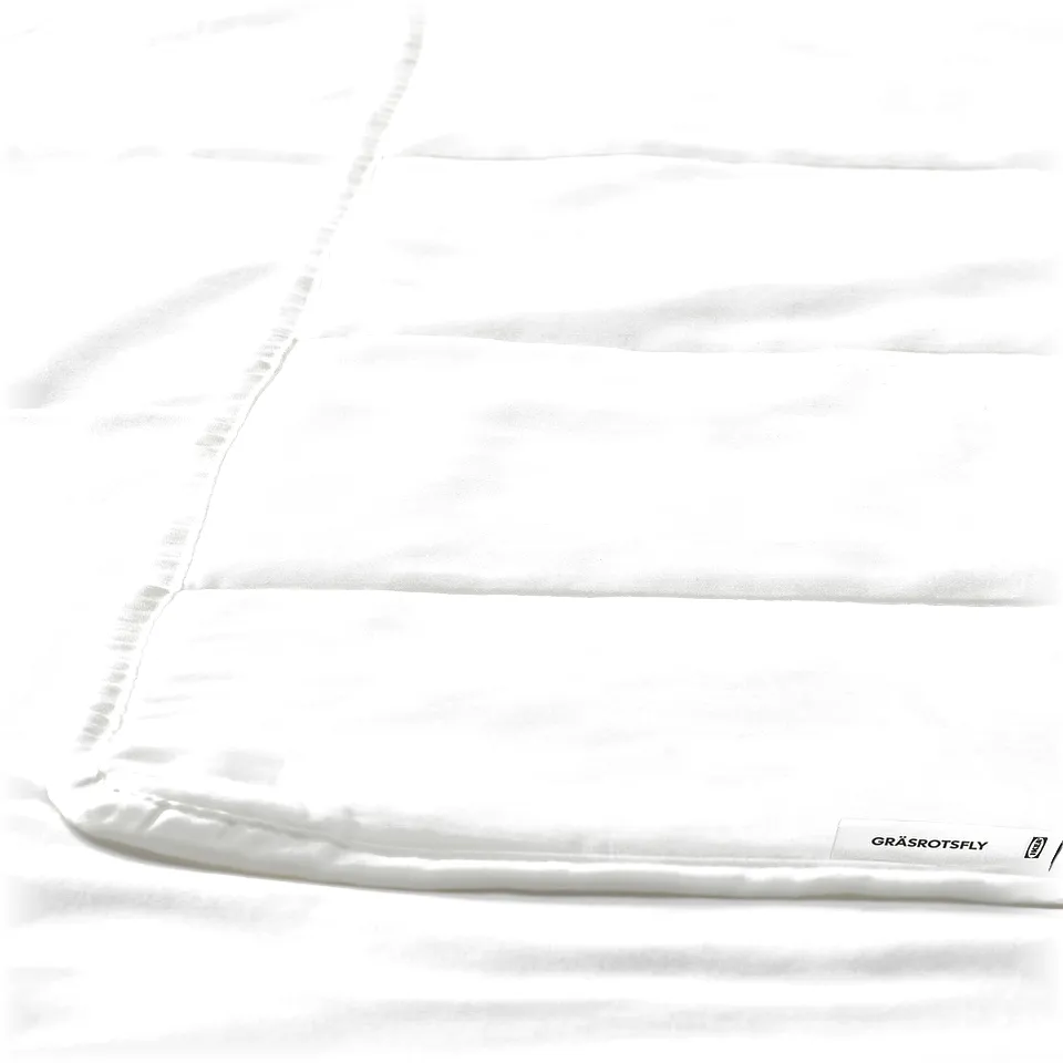 Close up of smooth, white duvet with subtle stitching, showcasing high-quality fabric.