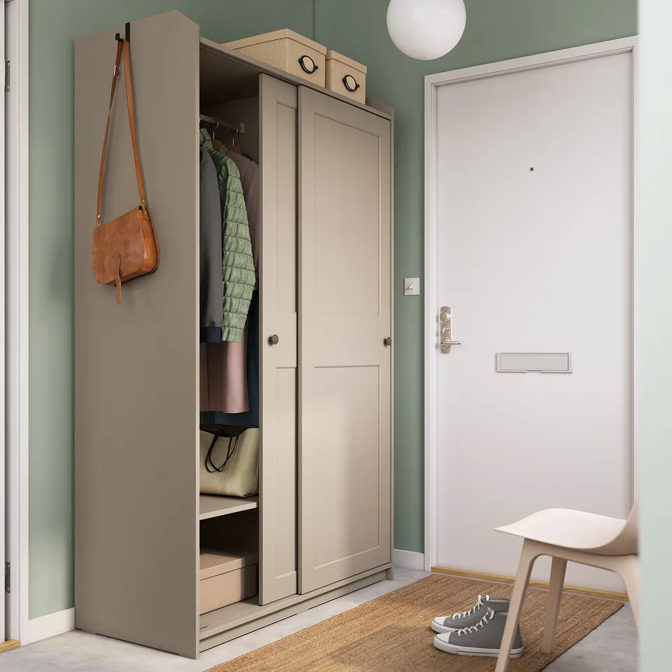 Modern beige HAUGA wardrobe with open door, inside storage & shelves, wall-mounted.