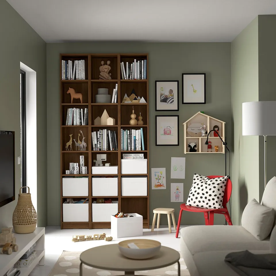 Cosy living room with BILLY bookcase, sofa, red chair, and artwork.