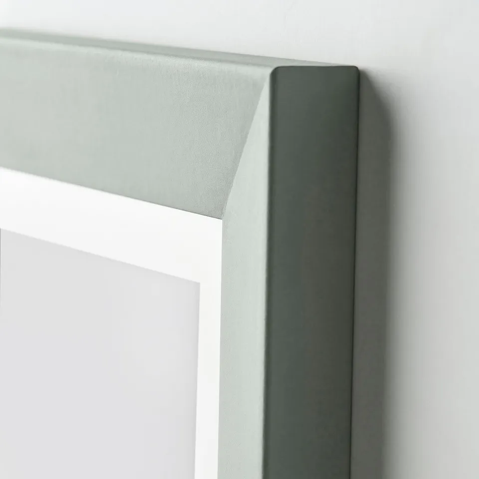 Close-up of grey-green plommontrad frame corner, showing sturdy design and white inner detail.