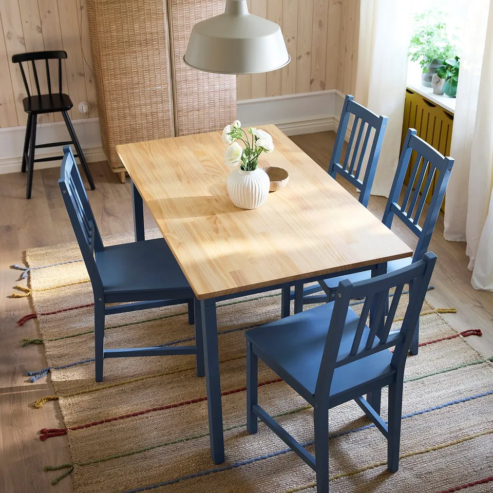 Wooden dining set with blue chairs, perfect for small spaces.