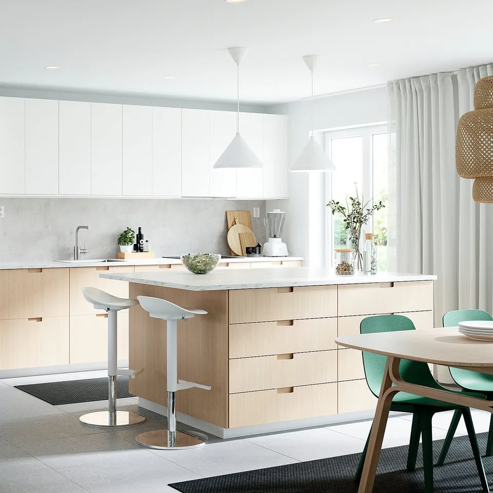 Modern kitchen with bamboo & white cabinets, island, green chairs, large window.