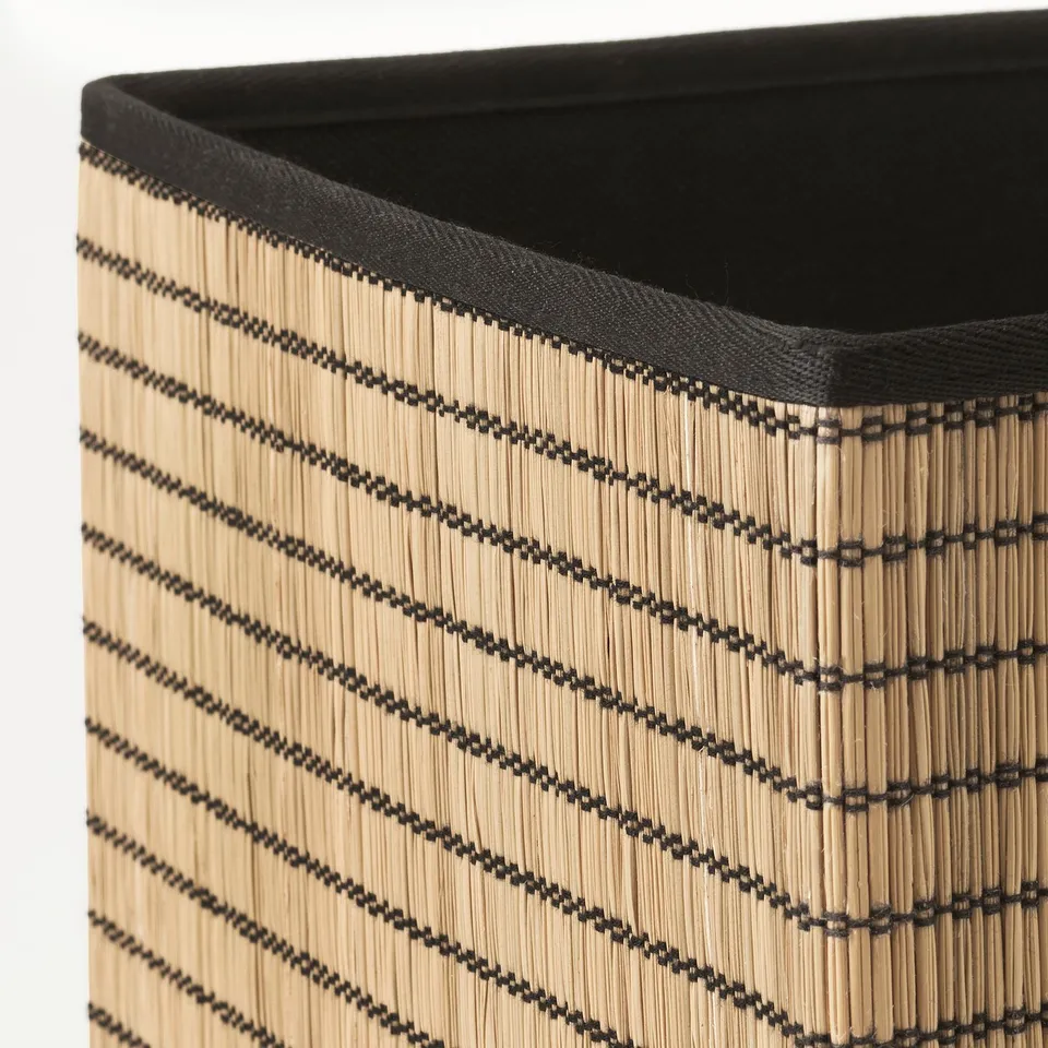 Wicker basket with black stripes, sturdy and stylish, perfect for storage.