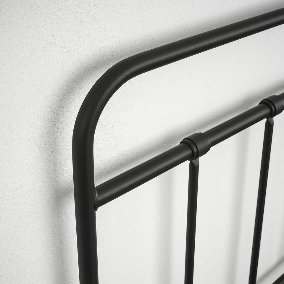 Black metal bed frame with curved headboard and footboard; sturdy, modern design.