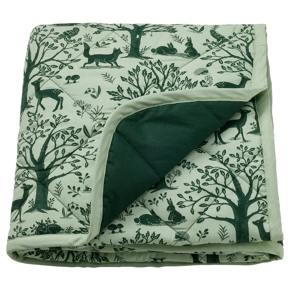 TROLLDOM green baby blanket with woodland creatures, soft recycled polyester filling, light sage colour, square shape, decorative pattern.