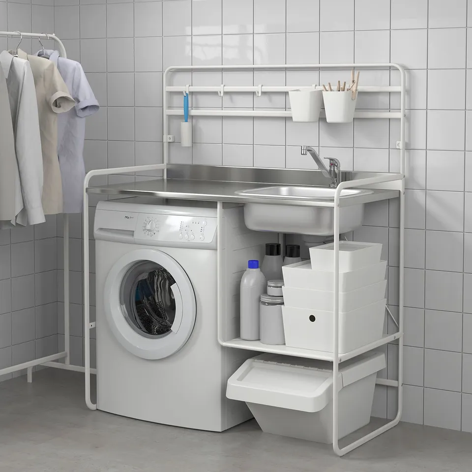 Laundry area setup with washing machine, sink, storage, and drying rack.