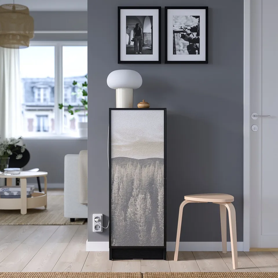 Modern room with BILLY bookcase, stool, table, lamp, and photos.