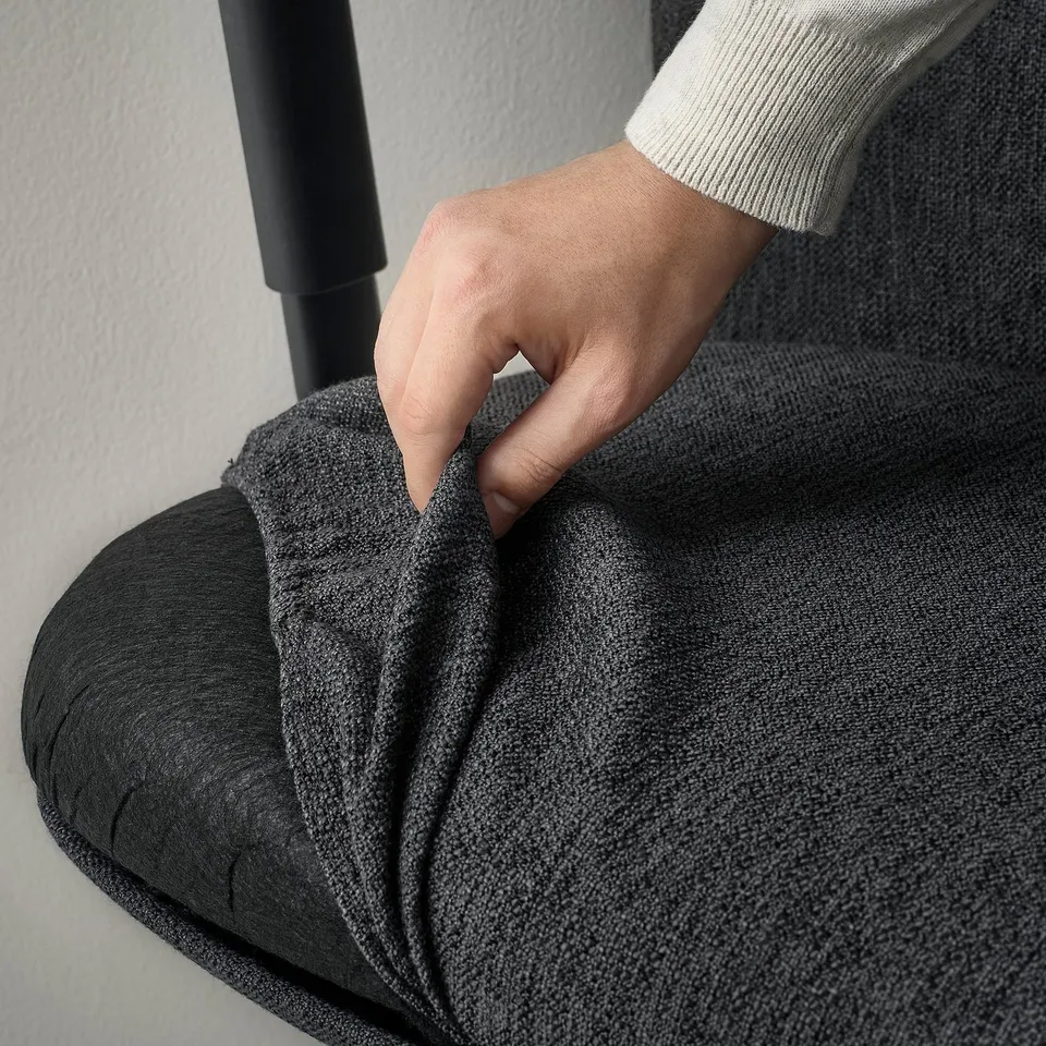 A hand adjusts lumbar support on an ergonomic office chair, ensuring comfort and proper back support.
